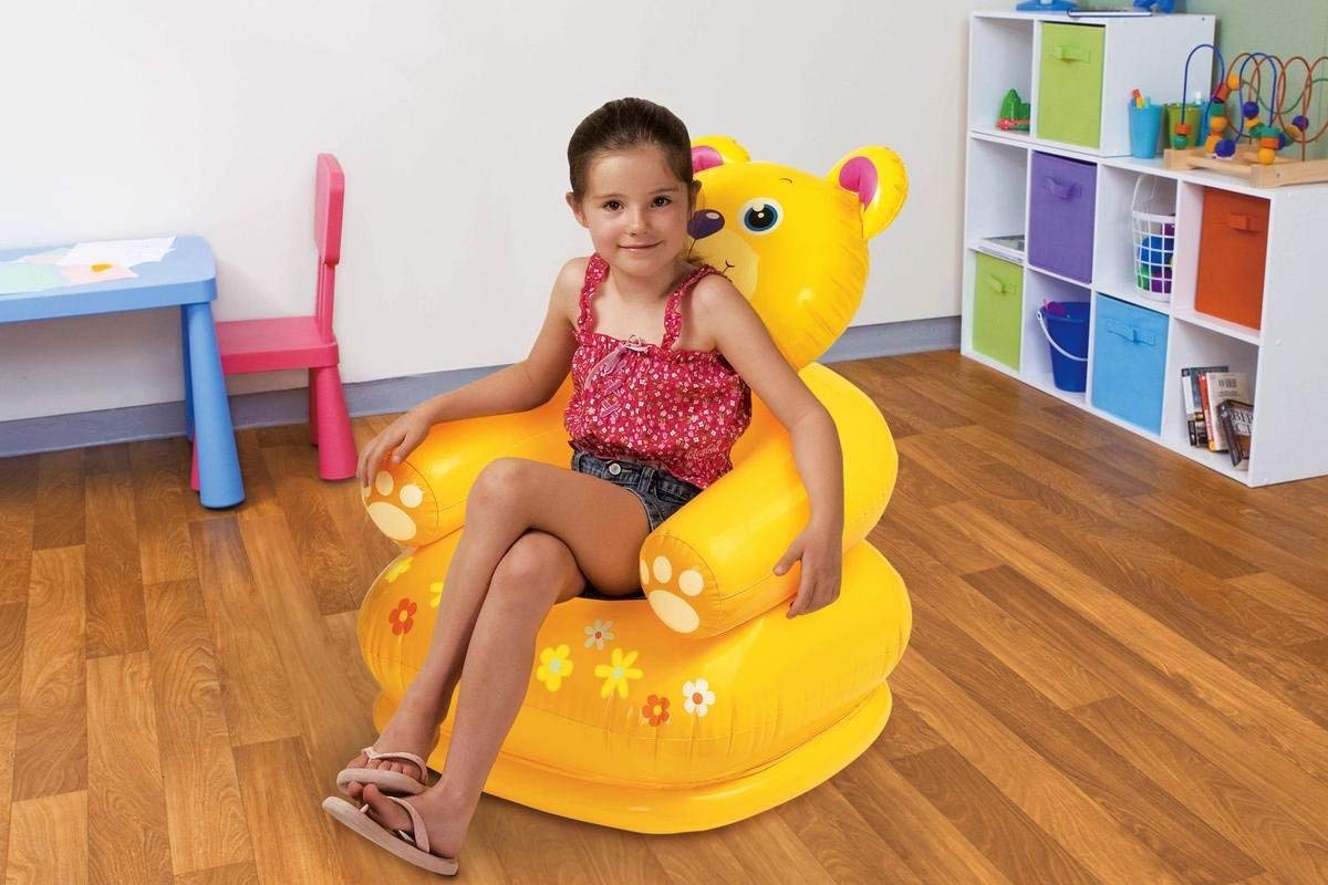 Young girl sitting on a yellow inflatable teddy bear chair, providing a fun and comfortable seating experience