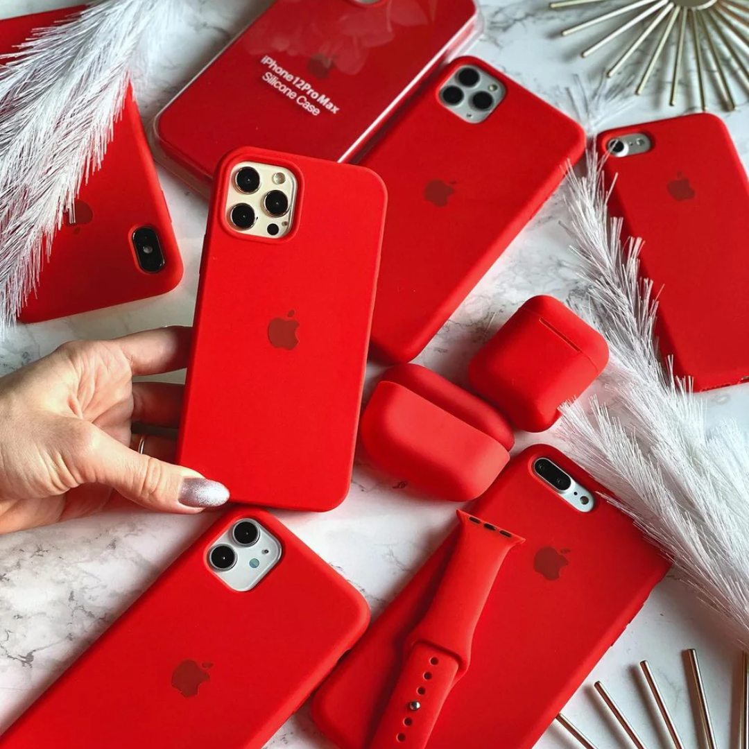 A collection of red Apple covers including iphone 15 pro max cover, AirPods case, and watch straps perfect for a coordinated tech look