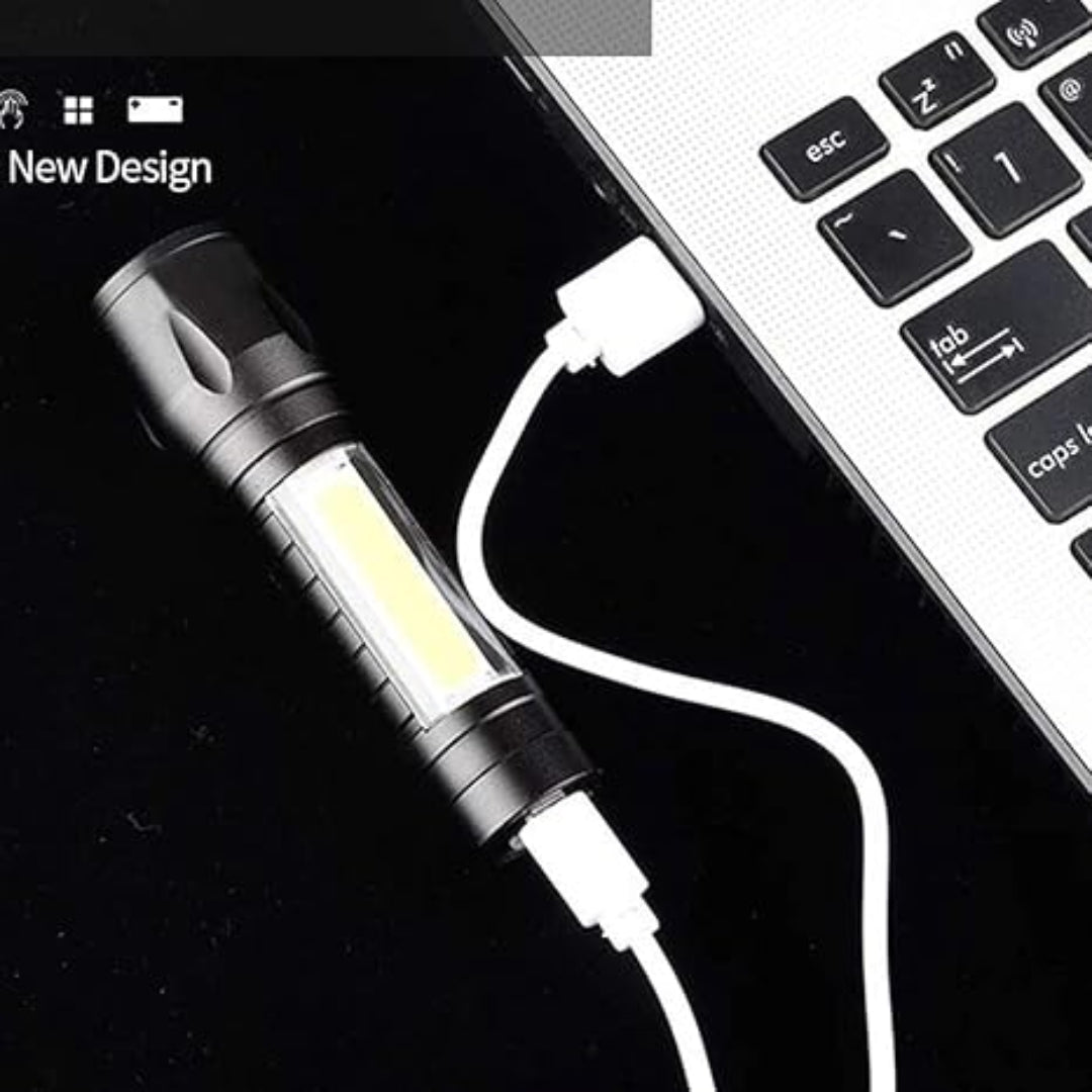 USB flashlight connected to a laptop for charging via a white cable