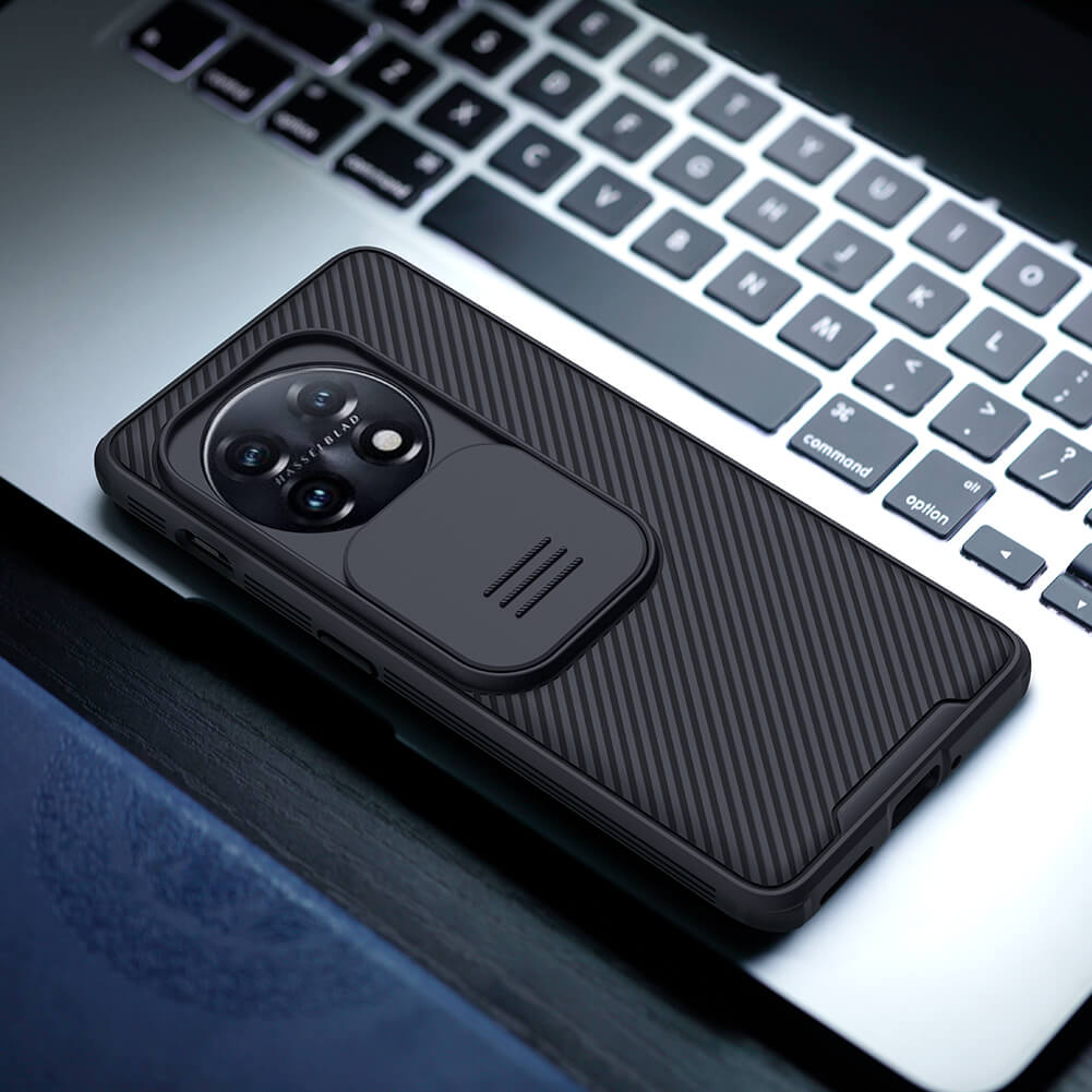Black OnePlus 11 case with textured finish placed on a laptop, portraying a modern and tech savvy lifestyle