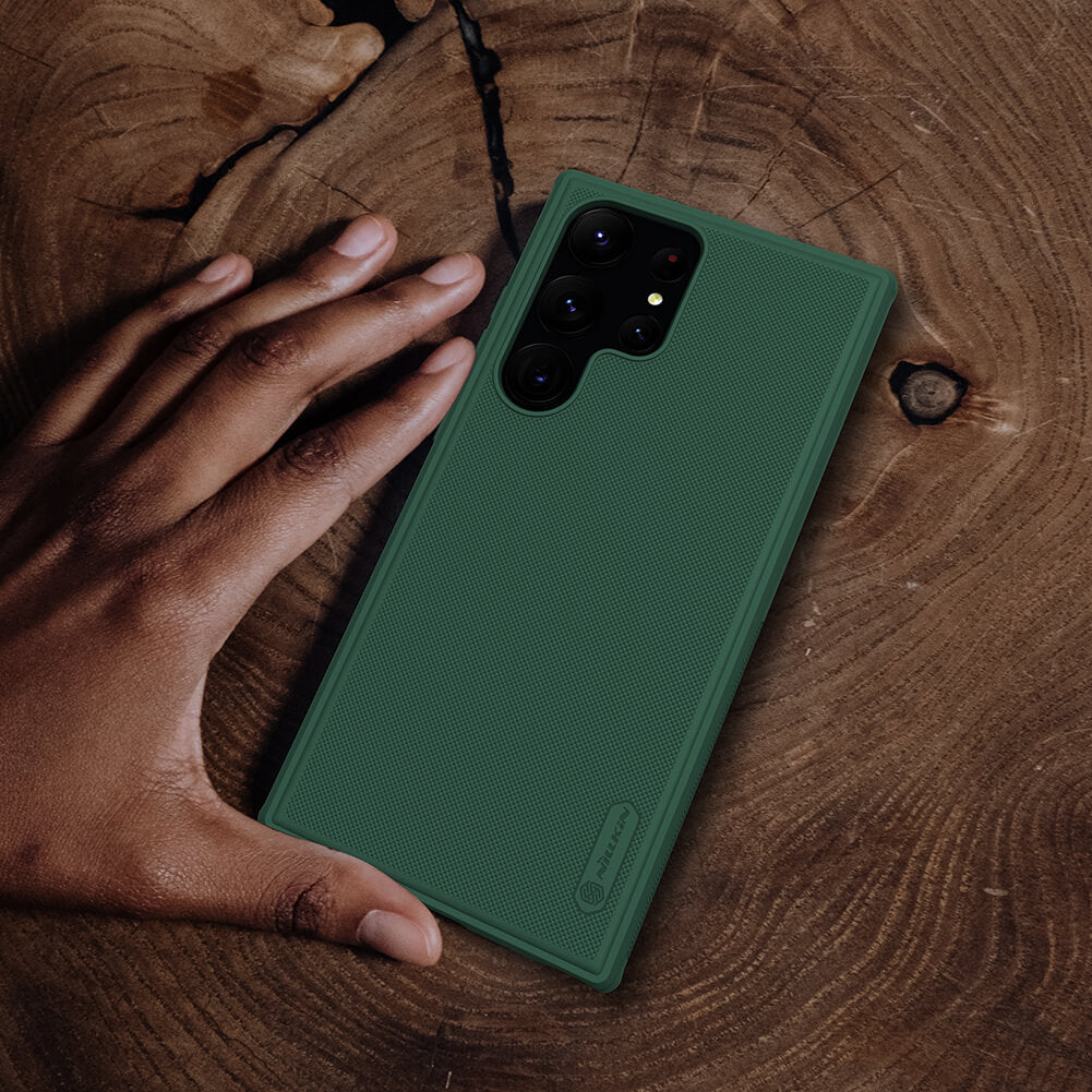 Dark green Super Frosted Shield Pro matte phone case displayed on a wooden surface, s23 ultra cover highlighting camera cutouts and edge grip.