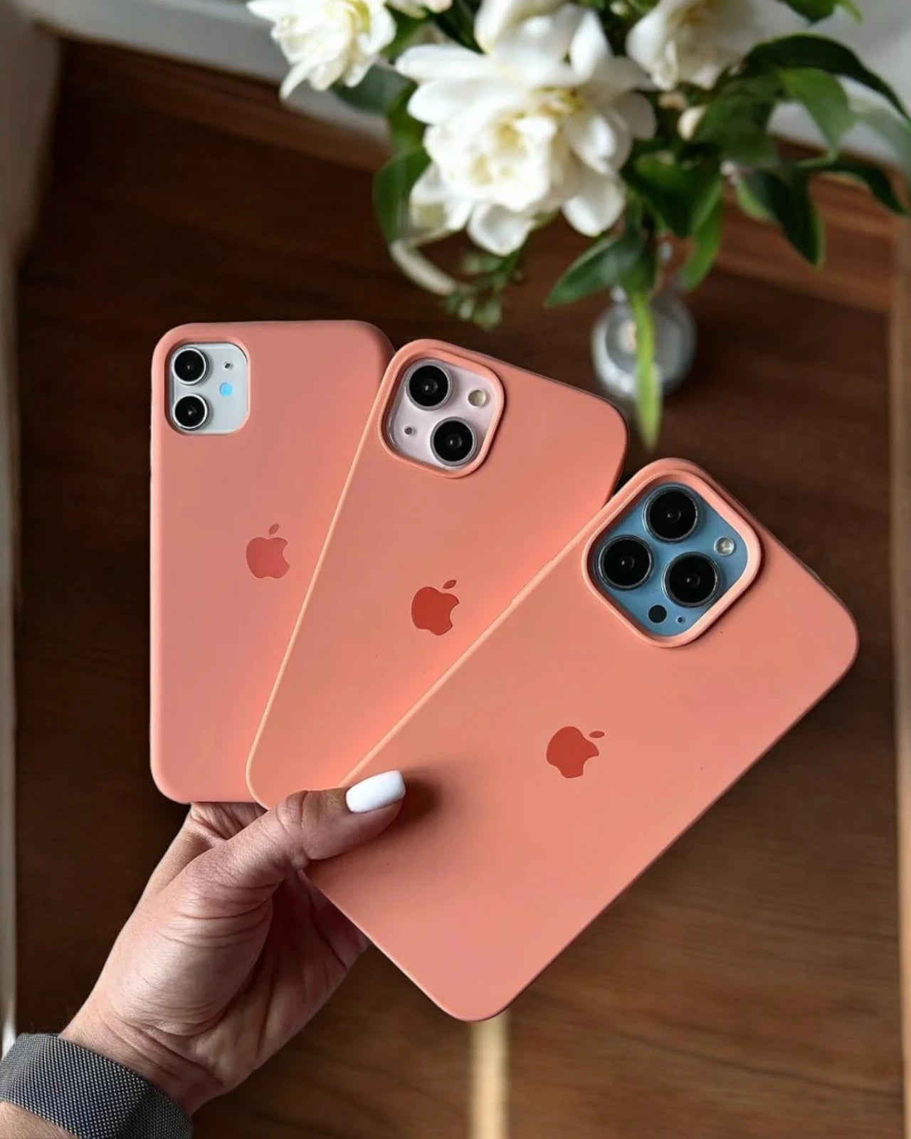 Peach pink liquid silicone iPhone cover with Apple logo, iphone 16 cover offering a soft matte finish and full camera cutout.