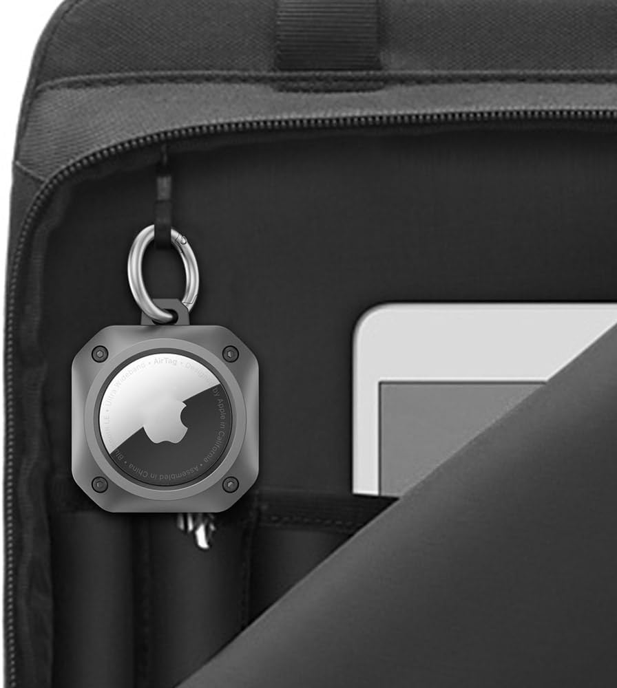 AirTag securely clipped onto a black laptop bag using a durable keychain case for added travel safety.