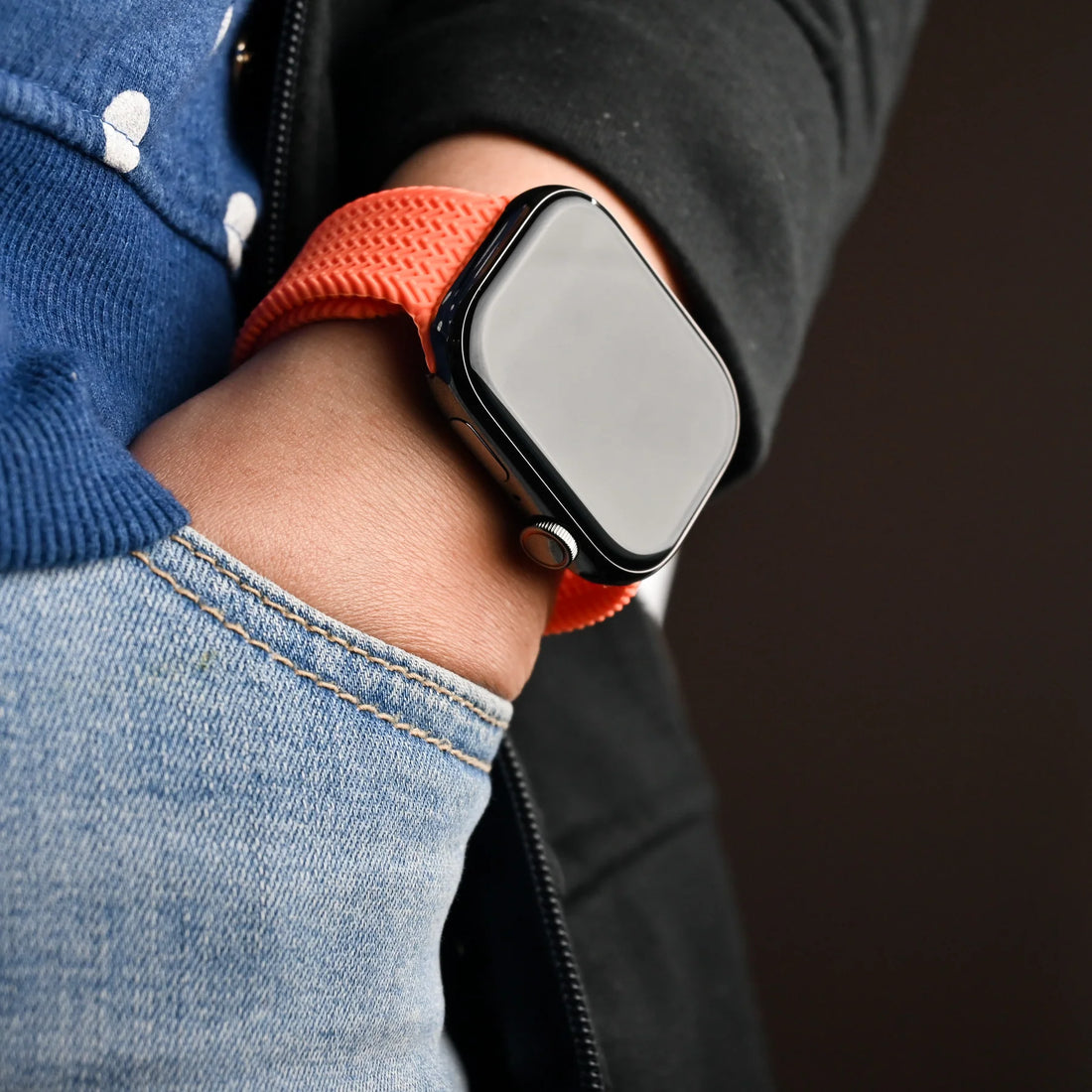 A close up of an Apple Watch featuring a vibrant orange apple watch straps, showcasing its sleek design and modern technology.