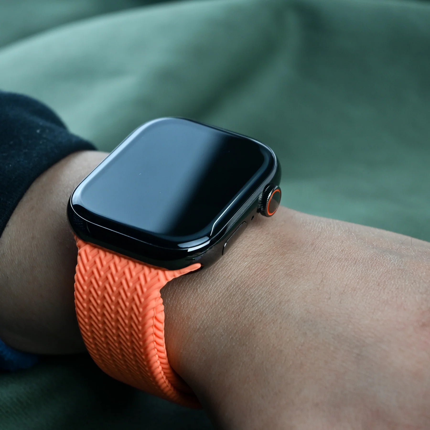 Close up of an Apple Watch with a orange apple watch straps, prominently displaying comfortability, blending functionality and style