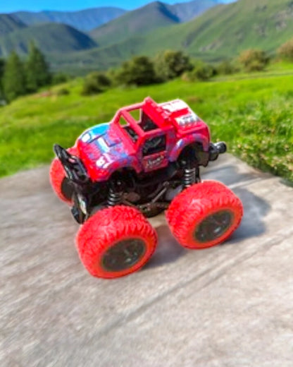 a Red Monster Truck with Large Textured wheels sits on a concrete surface 
