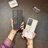 Black and beige leather Samsung covers held side by side, both with kickstand support for hands free use for S25 Ultra