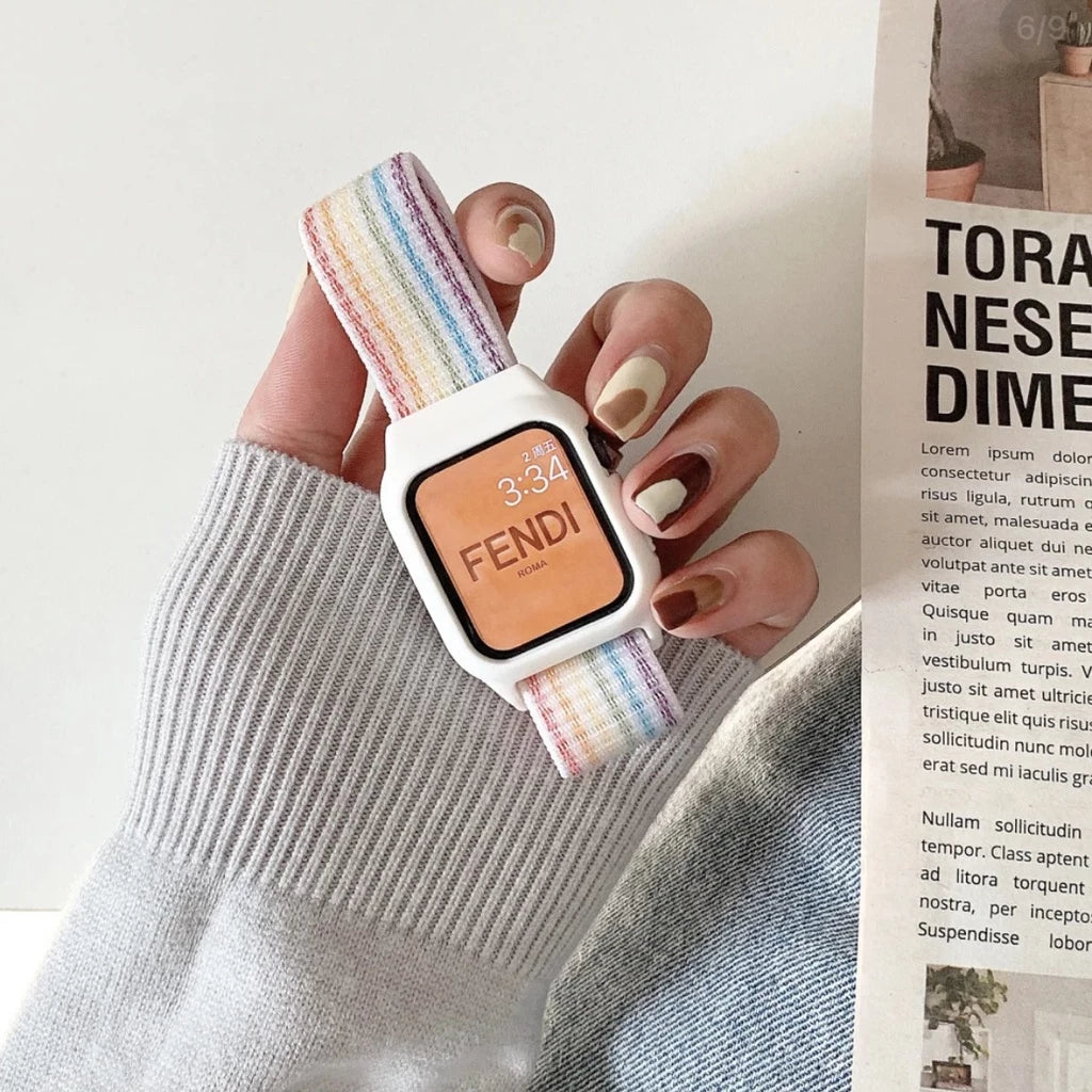 A hand holding a vibrant rainbow colored apple watch straps, showcasing its bright hues and unique design.