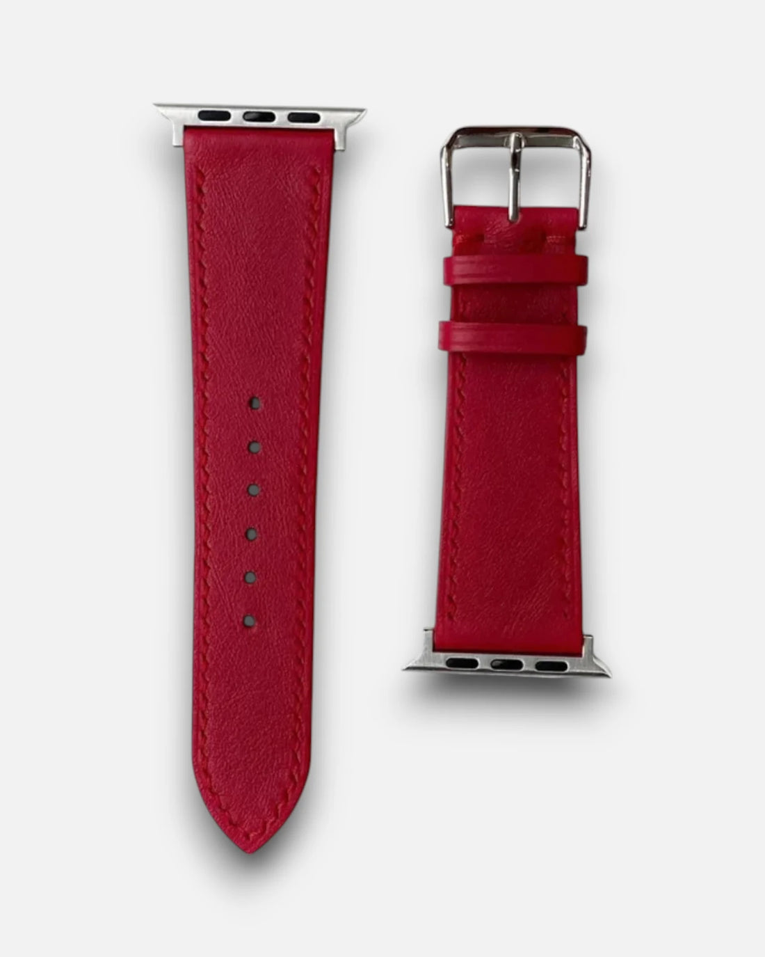 A detailed view of a red leather apple watch straps, complete with a shiny silver buckle for a chic look.