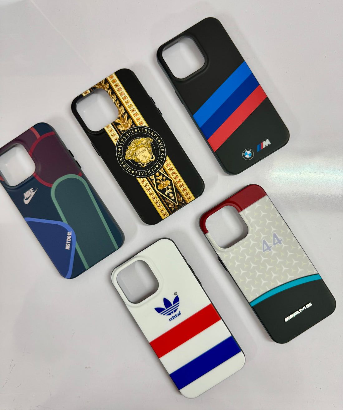  A collection of five stylish iPhone cases, iphone 15 pro max cover  featuring luxury and sports brand inspired designs, perfect for adding a premium touch to your device.